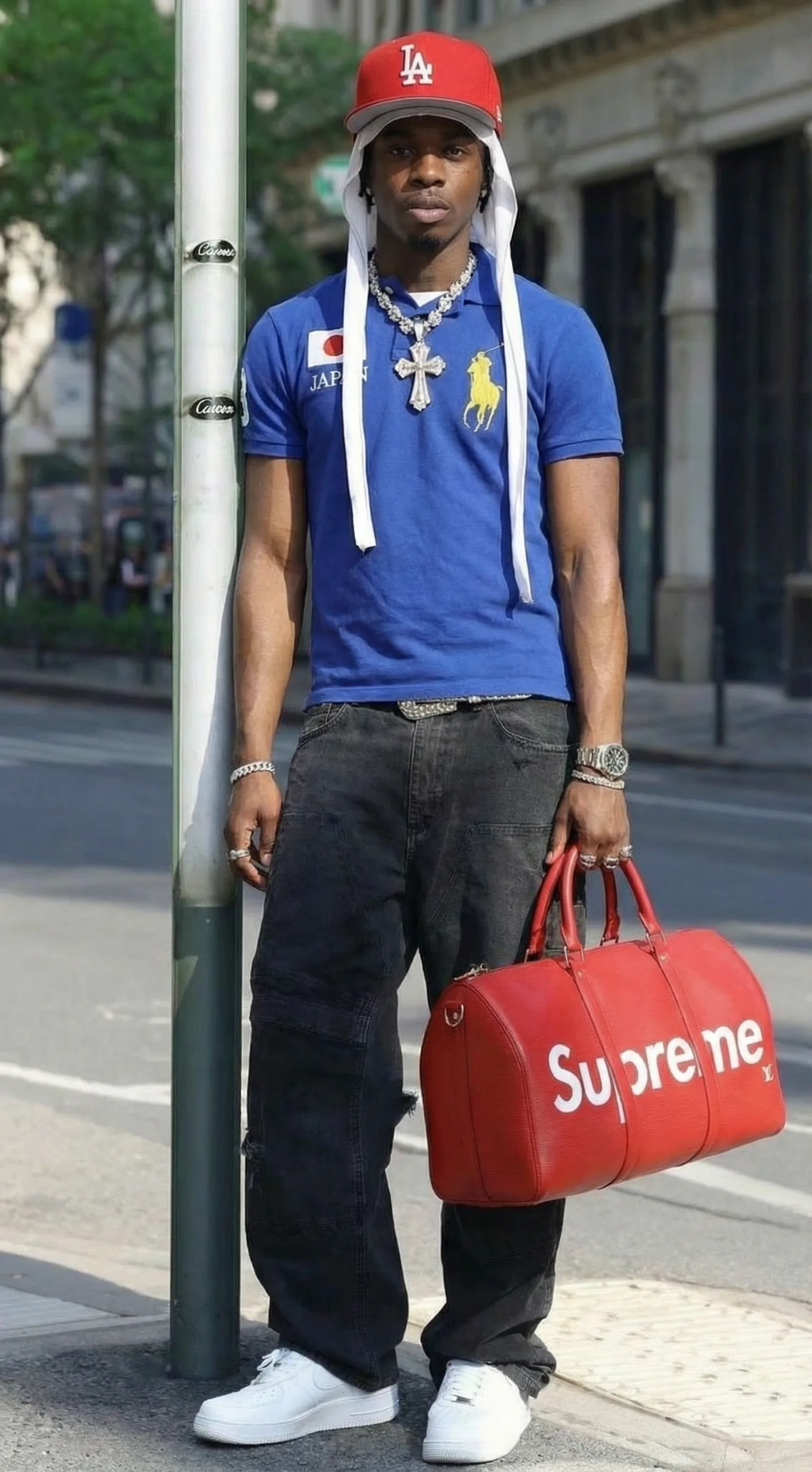 Higgsfield Soul ID test image: full-length shot of the same man leaning on a pole, holding the red duffel bag